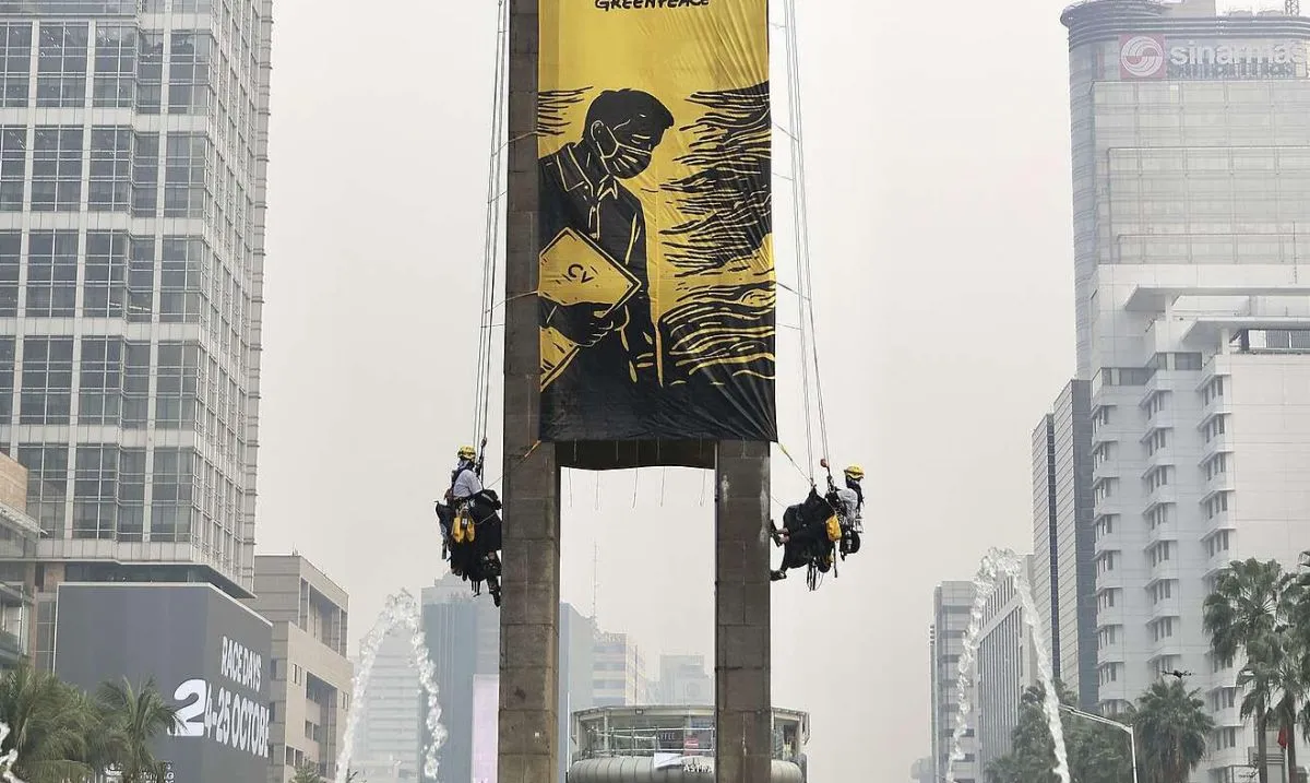 Enam aktivis Greenpeace Indonesia dievakuasi setelah membentangkan spanduk di Monumen Selamat Datang, Bundaran HI, Jakarta Pusat. (Posnews/Greenpeace Indonesia)

