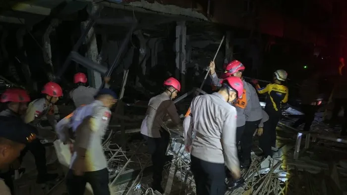 Personel Brimob dan polisi mengevakuasi korban serta mengamankan reruntuhan ruko setelah ledakan di Pasar Cimanggis, Ciputat, Tangerang Selatan. (Posnews/Ist)
