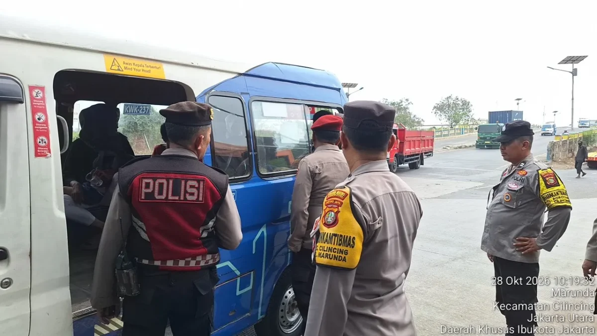 Personel kepolisian memantau pergerakan rombongan di titik pengawasan Jakarta Utara menjelang demonstrasi Hari Sumpah Pemuda.
