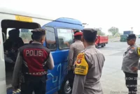 Personel kepolisian memantau pergerakan rombongan di titik pengawasan Jakarta Utara menjelang demonstrasi Hari Sumpah Pemuda.