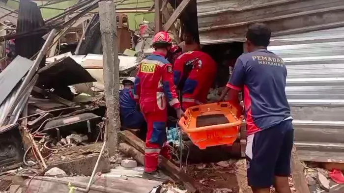 Petugas Damkar Jakarta Timur mengevakuasi pria yang tertimpa reruntuhan kios bakso di Kelapa Dua Wetan, Ciracas. (Posnews/Damkar)