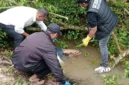 Petugas kepolisian melakukan penanganan tempat kejadian perkara penemuan jasad Muhammad Imran di parit perkebunan sawit di Dadimulyo, Asahan. (Posnews/Ist)