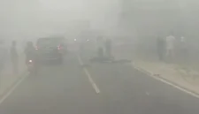 Petugas menangani kecelakaan sepeda motor dan truk yang menewaskan dua orang di Jalan Jenderal Sudirman, Sampit, saat kabut asap menyelimuti kawasan.