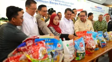 Petugas menunjukkan barang bukti beras fortifikasi yang diduga tidak sesuai klaim kandungan gizi.


